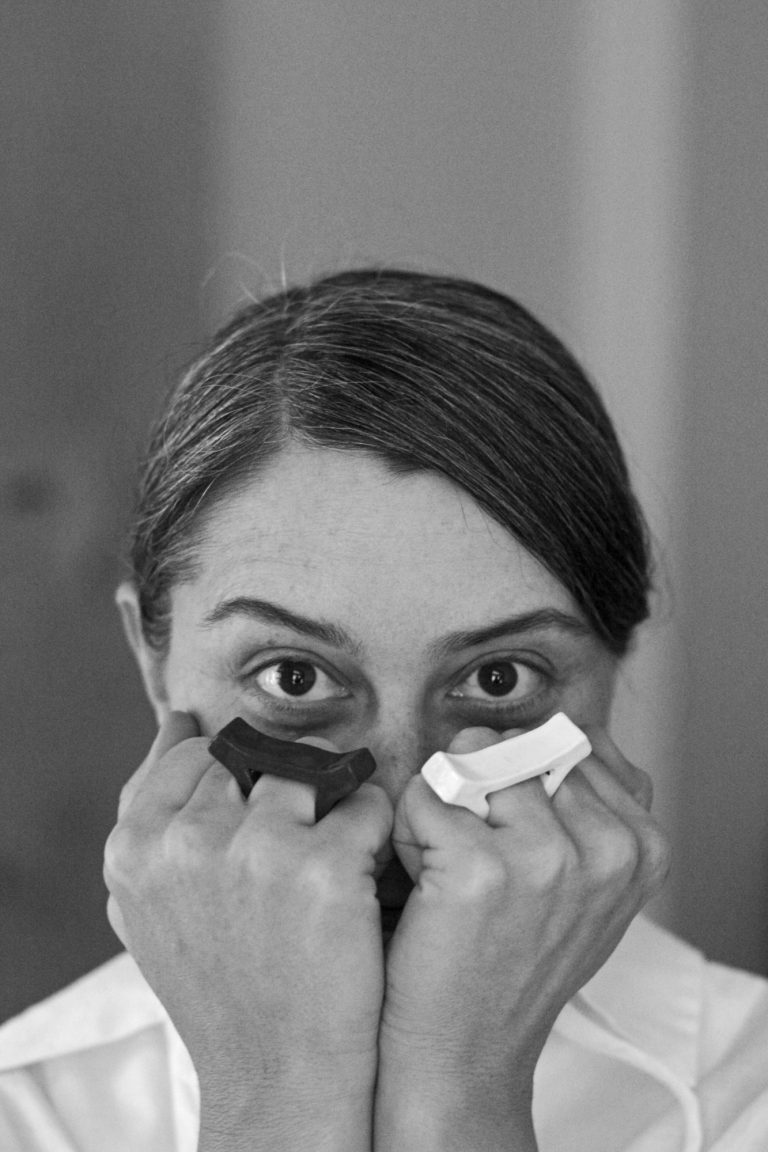 woman covering her face with her hands, wearing rings