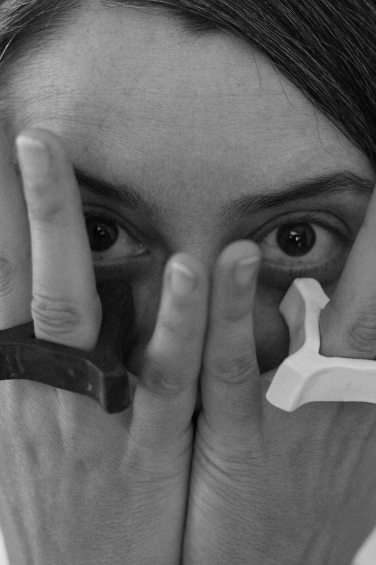 woman covering her face with her hands, wearing rings