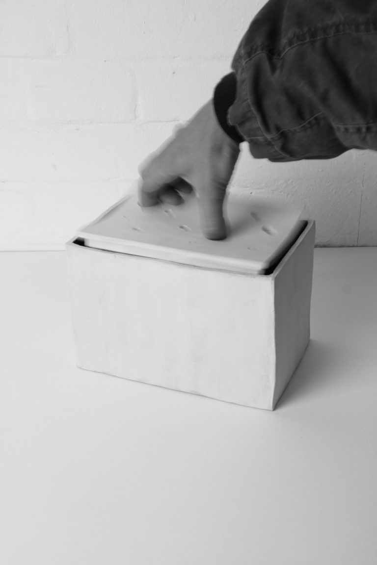 ceramic vase with hand that holds the lid