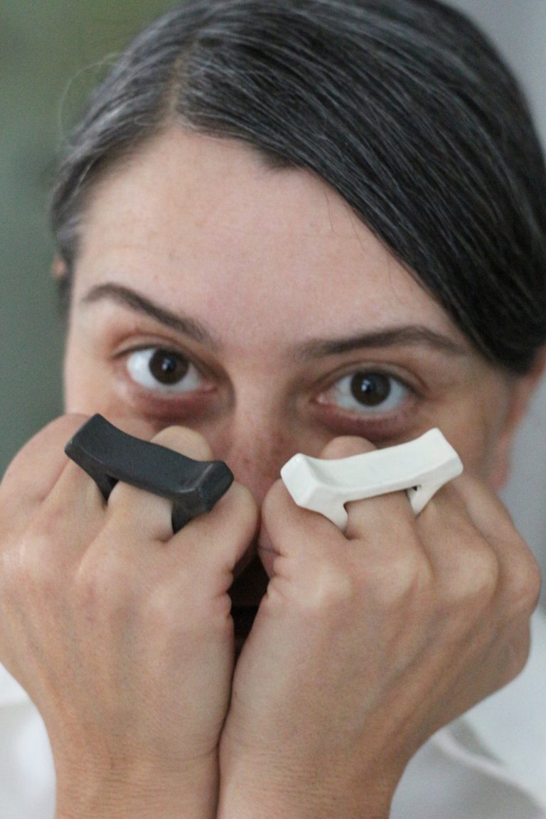 woman covering her face with her hands, wearing rings