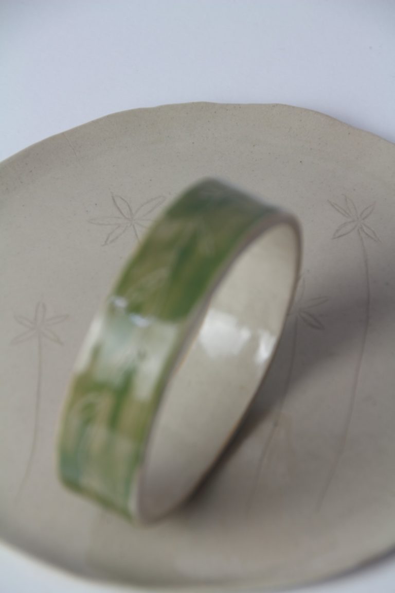 ceramic dish with green bracelet on it